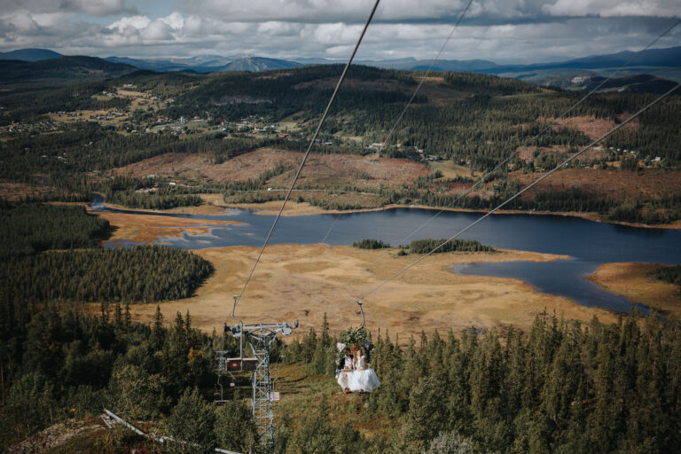Brudpar kommer i skidlift under sitt fjällbröllop